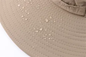 Waterproof sun hat detail showing close-up fabric texture and water-repellent performance outdoor.