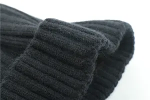 Close-up view of black winter ribbed knit beanie, showing thick texture and warm fabric details.