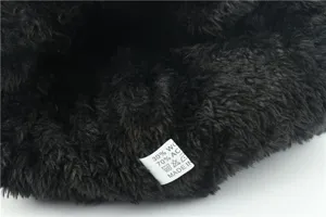 Close-up detail of winter fleece-lined beanie interior showing soft wool blend wash tag.