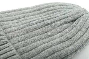 Close-up view of grey ribbed knit winter beanie hat showing soft texture and cozy warmth details.