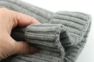 Close-up detail of grey ribbed knit beanie fabric, showing soft texture and thickness.