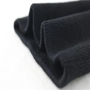 Close up view of black knitted fabric texture, showing soft ribbed detail for cozy apparel design.