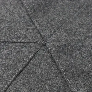 Detailed close-up of grey wool felt winter hat fabric texture with neat white stitching.