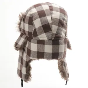 Detail view of brown white plaid trapper hat, warm winter faux fur earflap bomber hat.