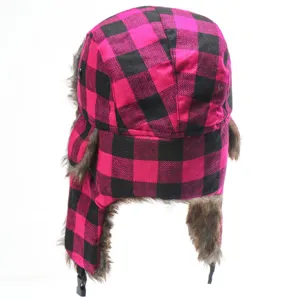 Detailed view of the pink and black plaid ushanka hat, thick fleece ear flaps for winter.