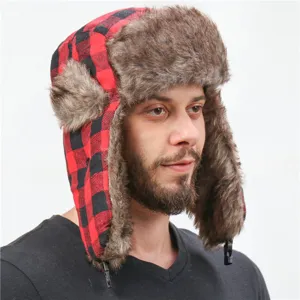 Detailed view of red black plaid trapper hat with soft faux fur ear flaps for cold weather.