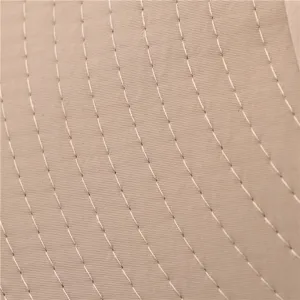 Close-up detail of khaki bucket hat fabric texture with neat parallel stitching lines.