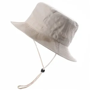 Detailed view of beige bucket hat with adjustable chin strap and breathable eyelets