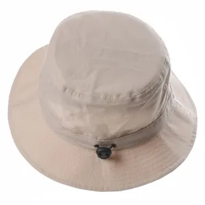 Close-up detail of beige bucket hat showing adjustable cord and textured fabric structure.