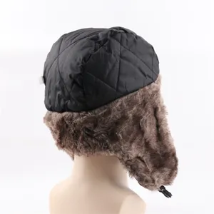 Detailansicht einer schwarzen gesteppten Trapper-Mütze mit braunen Fellohren für den Winter.