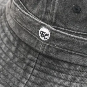 Vintage washed cotton bucket hat detail, dark grey outdoor fishing cap close-up display.