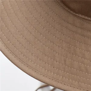 Gros plan de détail du bord du chapeau de soleil en coton, montrant de fines coutures.