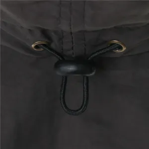 Detailed close-up view of adjustable drawstring and metal eyelets on dark outdoor sun hat.