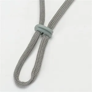 Close-up view of grey adjustable drawstring and plastic cord lock for hiking hat.