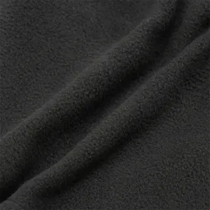 Primer plano de tela polar negra gruesa que muestra textura suave y detalles térmicos acogedores.