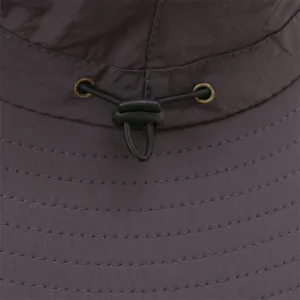 Detail view of solid color outdoor bucket hat with adjustable cord lock and fine stitching.