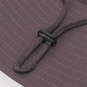 Detailed shot of bucket hat adjustable cord and strap, high quality outdoor sun hat design.
