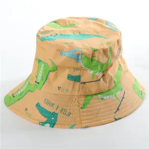 Detailed view of children cotton bucket hat with cute cartoon crocodile print pattern and yellow color.