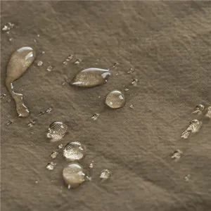 Close-up detail of waterproof brown fabric texture with water droplets for outdoor hats.