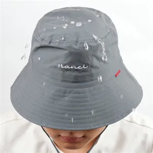Détail de chapeau bob imperméable montrant le tissu résistant à l'eau et le logo brodé.