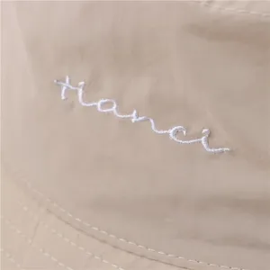 Chapeau bob imperméable minimaliste avec broderie blanche chic pour les journées ensoleillées.