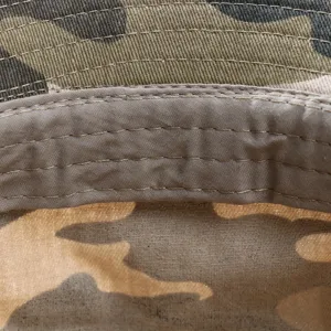 Detailed close-up view of a camouflage fisherman hat interior, showing neat stitching and fabric.