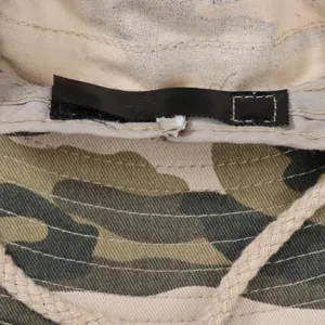Detailed close-up view of inner stitching and fabric tag on outdoor camouflage bucket hat.