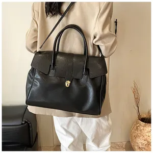 Gran bolso tote vintage negro llevado por la modelo, mostrando amplia capacidad.