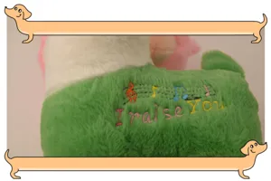 Detailed shot of cute musical plush sheep toy with embroidered notes, soft and cuddly gift.
