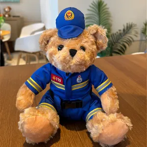 Plush teddy bear toy in blue firefighter uniform with badge and hat detail shot.