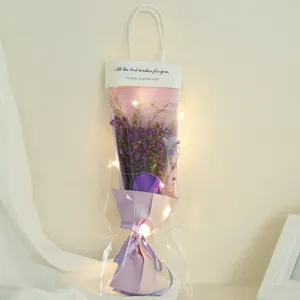 Purple dried flower bouquet with LED fairy lights in clear gift bag, romantic holiday gift style