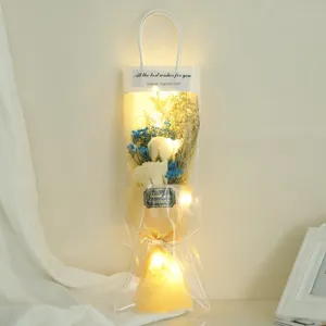 Handheld gift bag soap rose dried flower bouquet with warm LED string lights for romantic events.