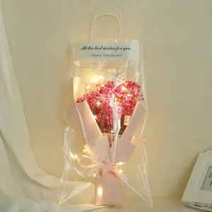 Romantic pink dried baby's breath bouquet inside clear gift bag featuring warm LED lights.