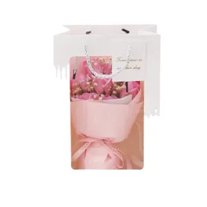 Pink rose bouquet in white gift bag with clear window, perfect romantic gift for lovers.