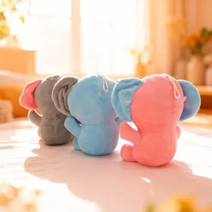 Detail view of cute plush elephant toys in grey blue and pink sitting cozy indoors.