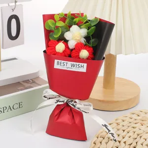 Detailed view of handmade crochet mini flower bouquet with red wrapping paper and ribbon.