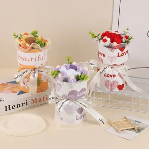 Detailed view of handmade knitted crochet flower bouquets placed in decorative gift boxes with ribbons.