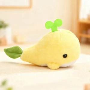 Cute yellow whale plush toy with green sprout and leaf design, soft stuffed animal doll.