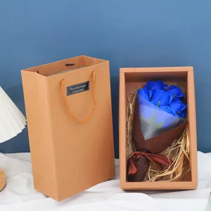 Detailansicht der blauen Seifenrosen-Blumenstrauß-Geschenkbox mit Papiertüte und Dekostroh.