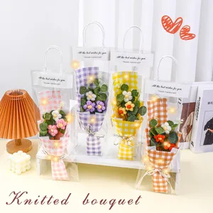 Handcrafted knitted flower bouquet with LED lights in transparent gift bag for festivals.