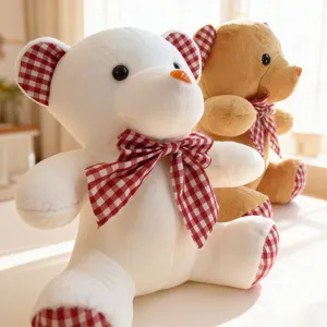 Detailed view of cute plush teddy bear toys with red checkered bowties sitting together.