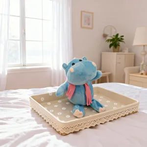 Detailed close-up shot of a cute blue plush hippo toy with pink scarf inside a tray.