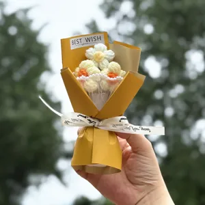 Close-up detail of handcrafted crochet flower bouquet with yellow wrapping and ribbon.