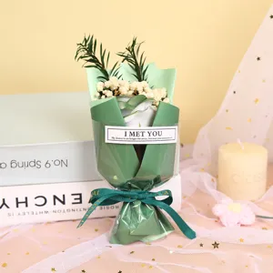 Close-up detail shot of the mini soap flower bouquet wrapped in green paper with ribbon gift.