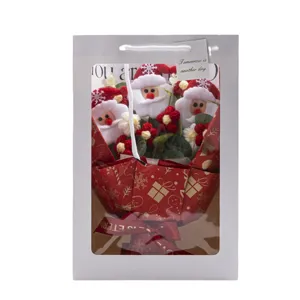 Handmade knitted crochet Santa Claus flower bouquet in white gift bag for Christmas gift.