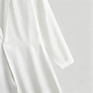 Detail view of a white long suit coat featuring single-button closure and fine stitching.
