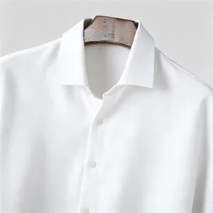 Close-up detail of mens white textured shirt collar and button placket, casual daily wear.