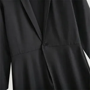 Detail view of the black single-button long coat lapel and cinched waist design.