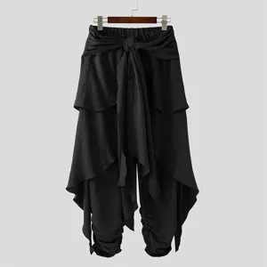 Men's black draped layered harem pants detail, featuring tie waist and ruched ankles.