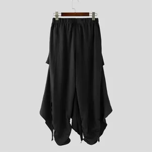 Detailed view of black layered harem pants featuring unique asymmetrical drape and relaxed fit.